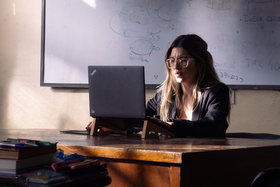 Profesor de inglés preparando actividades de clase con un portátil en el aula