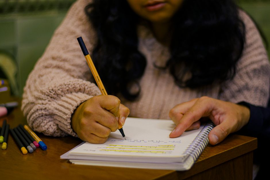 Materiales y ejercicios de inglés preparados junto a un portátil