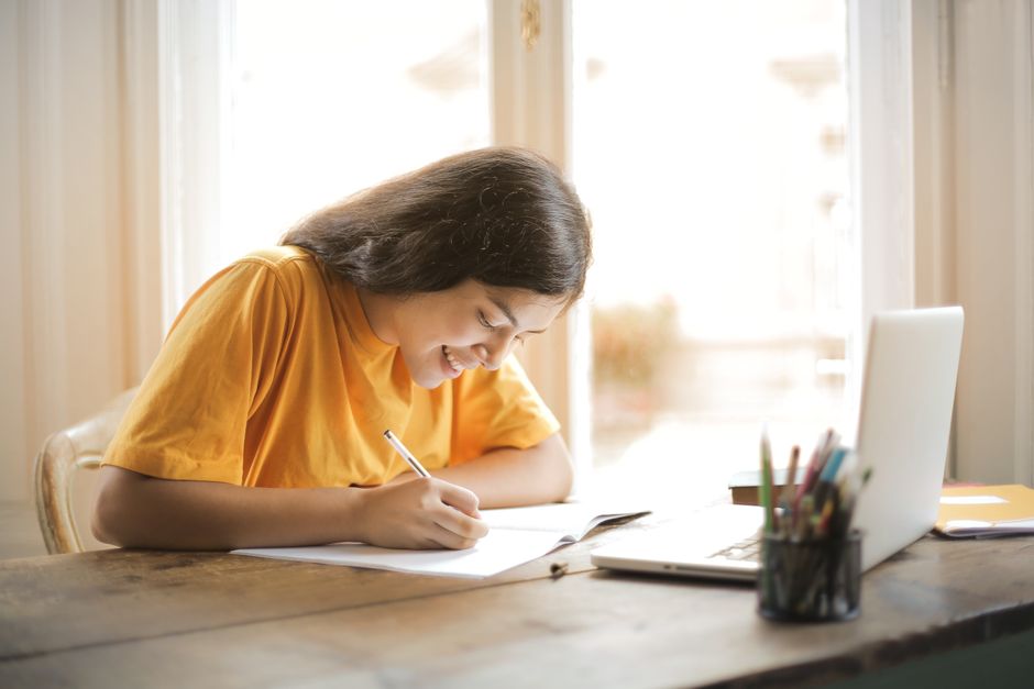 Estudiante usando ChatHistoria en el portátil para estudiar historia y tomar apuntes