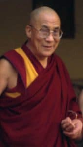Retrato de Tenzin Gyatso, XIV Dalái Lama, con expresión serena y vestimenta monástica tradicional.
