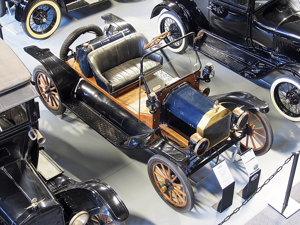 Ford Modelo T en una escena urbana de principios del siglo XX, símbolo de la popularización del automóvil
